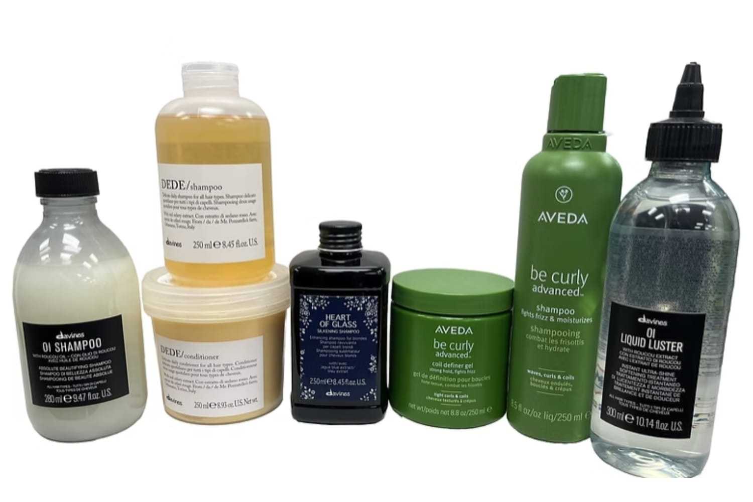 Various hair care products including shampoos, conditioner, and styling treatments in different bottles.